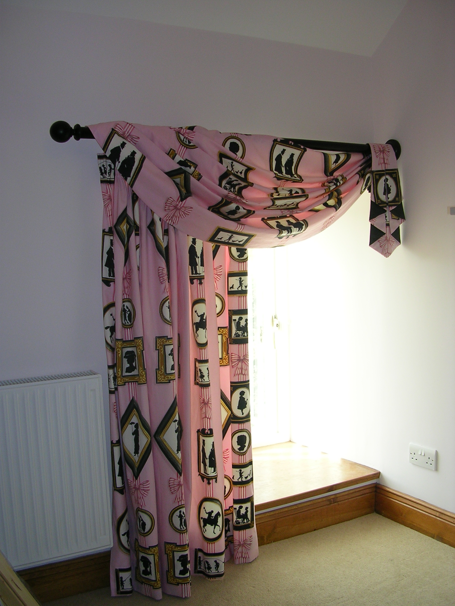 An elegant single swag draped over a pole with a tail